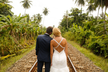 Wall Mural - bride and groom walking on railway