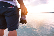 Man Holding His Camera On During His Travel. Photographer And Travel Concept.