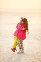 little girls sisters hugging and holding hands in nature. childr