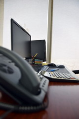 Office desk with computer and other items in the day