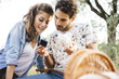 © juripozzi - Young couple in love doing a picnic outdoors in Tuscany wine country and taking a selfie with an instant camera