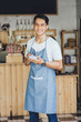 © Odua Images - asian male waiter in apron writing order