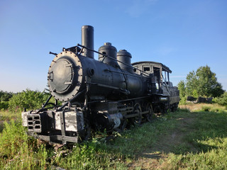 Vintage old antique train locomotive engine perspective in sun - landscape color photo