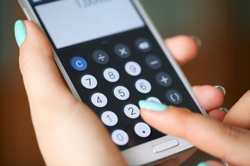 Woman hands working on calculator close up