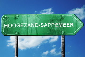 Hoogezand-sappemeer road sign, vintage green with clouds backgro