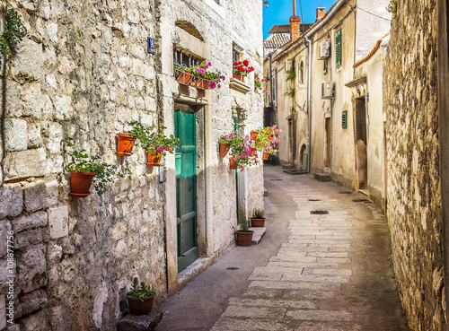 Naklejka dekoracyjna Narrow old street and yard in Sibenik city, Croatia, medieval zone