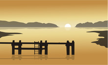 At Sunrise In Sea With Pier Silhouette