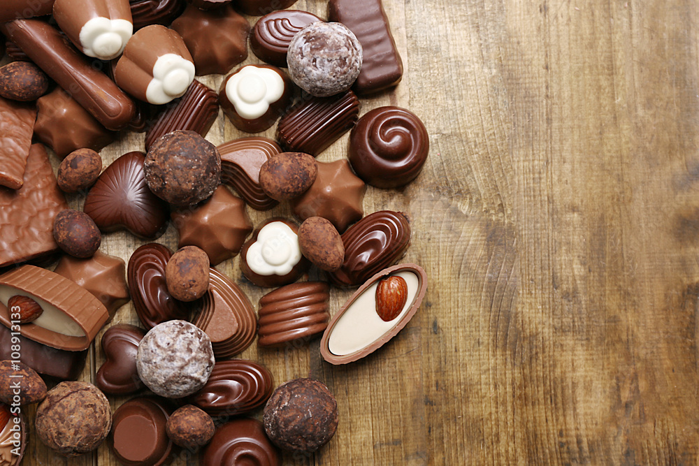 Delicious chocolate candies on wooden background
