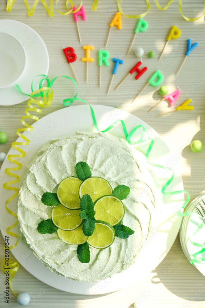Lime cake with birthday candles on wooden table