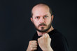© ilijaa - Serious aggressive man with beard and mustaches on black background in low key, holding fists and threatening, ready for fight