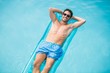 © WavebreakMediaMicro - Shirtless man relaxing on inflatable raft