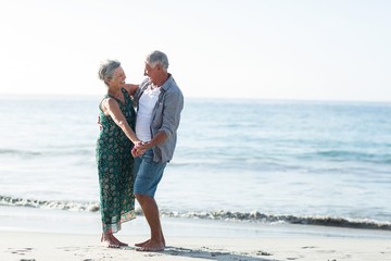 Wall Mural - Senior couple dancing at the beach