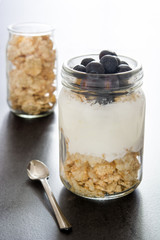 Wall Mural - Yogurt with blueberries on black background
