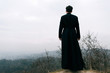 Portrait of handsome catholic bearded man priest or pastor posing outdoors in mountains