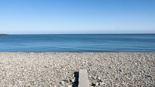 Pebble Stone Beach With Sea Defence And Pier On A Beautiful Day In Llandudno Wales UK