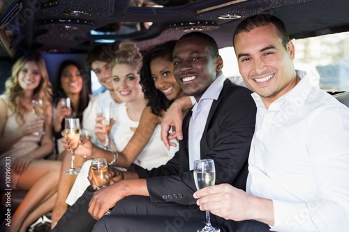 Photographie Well dressed people drinking champagne in a limousine