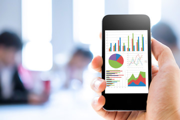 Poster - Close-up hand holding mobile phone with analyzing graph