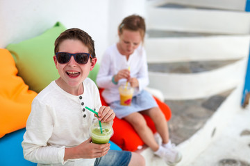 Wall Mural - Two kids drinking smoothies outdoors