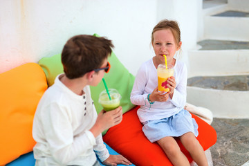 Wall Mural - Two kids drinking smoothies outdoors