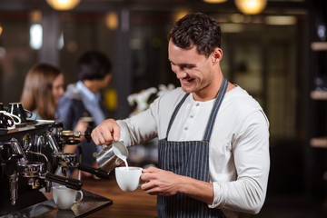 Wall Mural - Smiling barista preparing cappuccino