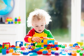 Wall Mural - Little boy playing with plastic blocks