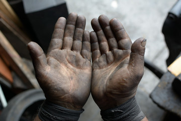 Worker hand covered with oil point of view