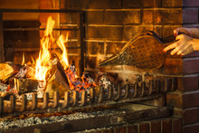 Closeup Hands Fireplace Making Fire With Bellows.