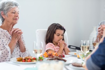 Wall Mural - Family praying together before meal