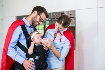 Wall Mural - Couple in superhero costume feeding milk 