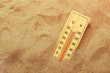 Thermometer on warm desert sand