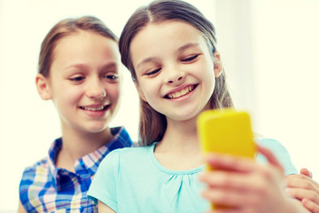 Wall Mural - happy girls with smartphone taking selfie at home