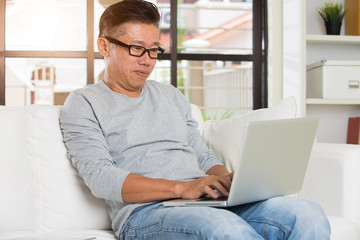 Man in living room with laptop smiling