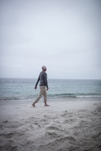 Senior Man Walking On The Beach