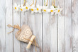 Narcissus flower, decorative heart on a light wooden background. Selective focus. Space for text.