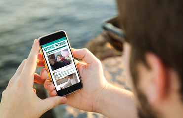 Poster - Man using his mobile phone on the coast showing social network