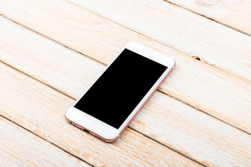 Mobile phone on wooden table background, clipping path inside