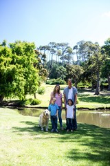 Wall Mural - Happy family standing in the park 