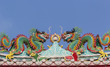 Double Chinese dragons on a temple roof with blue sky. 