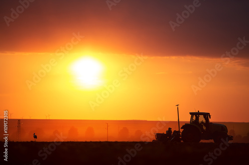 Foto Farmer in tractor preparing land with seedbed cultivator