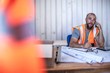 © Connect Images - Construction worker sitting at desk talking on smartphone in portable cabin