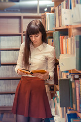 Girl reading book in library