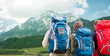 travelers with backpacks hiking in mountains