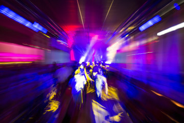 Wall Mural - Colourful night club party lights in motion blur, abstract background design, people dancing drunk or on drugs