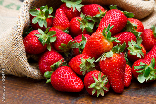 Naklejka nad blat kuchenny fresh strawberry in burlap sack on wood