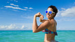 Funny playful woman showing arm biceps on tropical caribbean vacation. Fitness summer goals concept.