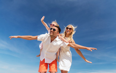 Wall Mural - happy family having fun over blue sky background