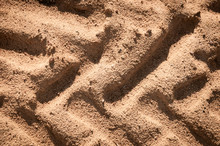Embossed Trail Excavator Tracks On The Wet Sand