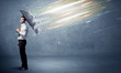 © ra2 studio - Business man defending light beams with umbrella concept