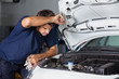 Male Mechanic Examining Car Engine
