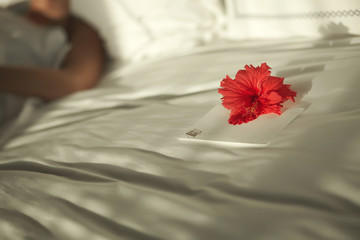 Lovely valentine letter on bed with flower.